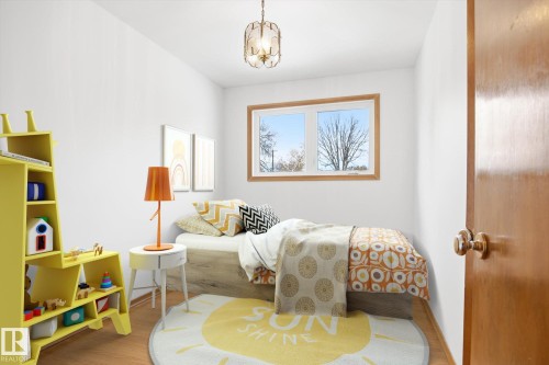 Bright room with white walls, a large window featuring outdoor views, and hardwood flooring - 6503 106A Avenue, Edmonton, AB - Indoor Photo Showing Bedroom