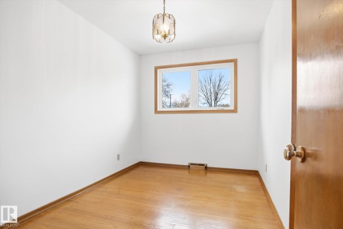 Room featuring hardwood floors, a window with exterior views, and a ceiling-mounted light fixture - 6503 106A Avenue, Edmonton, AB - Indoor Photo Showing Other Room