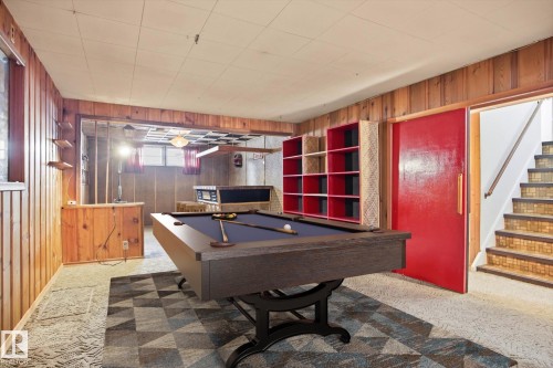 Recreation room featuring wood paneling, a pool table, and built-in shelving - 6503 106A Avenue, Edmonton, AB - Indoor Photo Showing Other Room