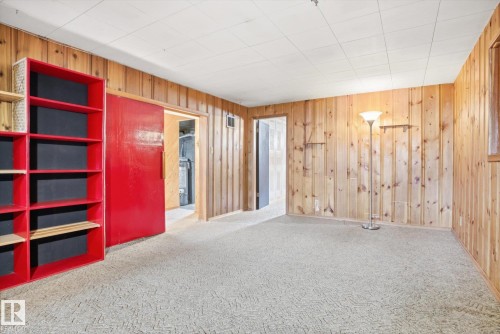 This room features wood-paneled walls and a patterned carpet - 6503 106A Avenue, Edmonton, AB - Indoor Photo Showing Other Room