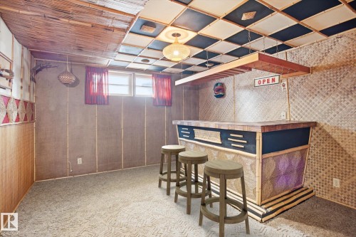 Recreational space with a built-in bar, decorative wall coverings, and a paneled ceiling - 6503 106A Avenue, Edmonton, AB - Indoor