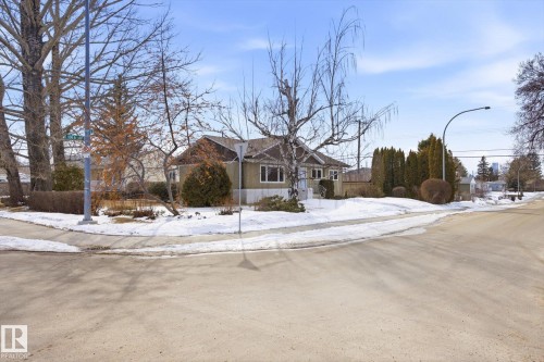The property features a corner lot with a well-maintained lawn and mature trees - 6503 106A Avenue, Edmonton, AB - Outdoor