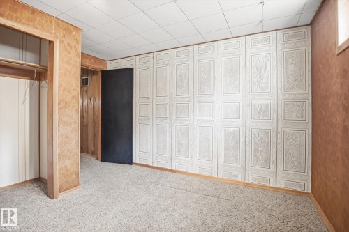 This versatile room features carpeted flooring, paneled walls, and a drop ceiling - 6503 106A Avenue, Edmonton, AB - Indoor Photo Showing Other Room