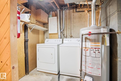 The property includes a dedicated laundry area with a white washing machine and dryer, alongside a water heater - 6503 106A Avenue, Edmonton, AB - Indoor