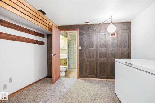 The property features carpeting, wood paneling, and an exposed wood beam ceiling detail - 6503 106A Avenue, Edmonton, AB - Indoor Photo Showing Laundry Room