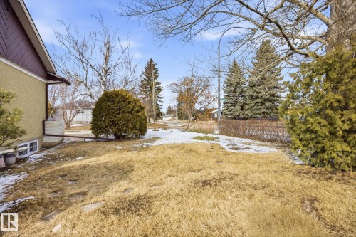 The property features a partial stucco exterior, a sloped roofline, and a yard with a mix of grass and snow - 6503 106A Avenue, Edmonton, AB - Outdoor With View