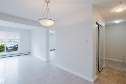 This bright interior features light-colored flooring, a window with blinds, and an overhead light fixture - 113 309 Clareview Station Drive, Edmonton, AB - Indoor Photo Showing Other Room