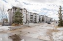 The property features a multi-story apartment building with balconies, a paved drive, and a stone retaining wall - 113 309 Clareview Station Drive, Edmonton, AB  - Outdoor 
