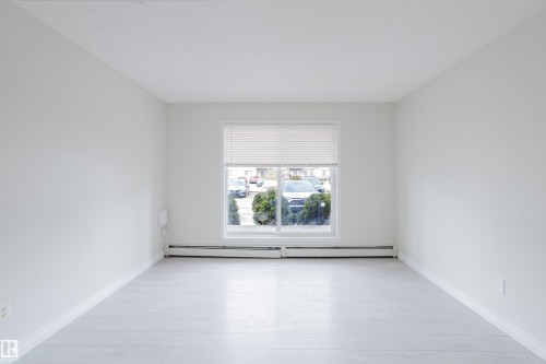Open concept room featuring light-colored flooring, white walls, and a window with blinds - 113 309 Clareview Station Drive, Edmonton, AB - Indoor Photo Showing Other Room