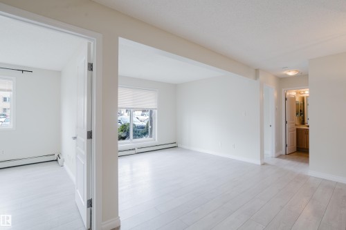 Living area featuring light-toned flooring, white walls, and a window with a roller blind - 113 309 Clareview Station Drive, Edmonton, AB - Indoor Photo Showing Other Room