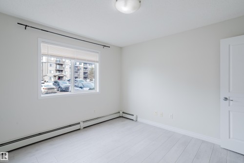 This room features light-colored flooring, a window with blinds, and white walls, creating a bright and airy atmosphere - 113 309 Clareview Station Drive, Edmonton, AB - Indoor Photo Showing Other Room
