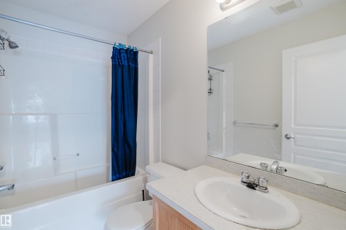The bathroom features a bathtub with a shower, a vanity with a sink and faucet, and a toilet - 113 309 Clareview Station Drive, Edmonton, AB - Indoor Photo Showing Bathroom