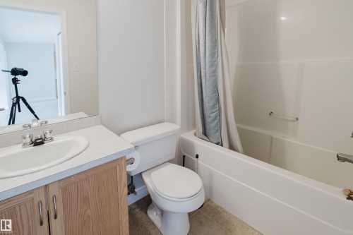 The bathroom features a vanity with a white sink, a toilet, and a bathtub with a shower - 113 309 Clareview Station Drive, Edmonton, AB - Indoor Photo Showing Bathroom