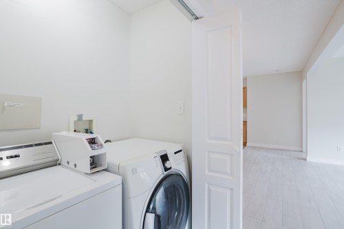 The property features a dedicated laundry area with a white top-loading washing machine and a white front-loading dryer - 113 309 Clareview Station Drive, Edmonton, AB - Indoor Photo Showing Laundry Room
