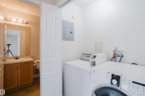 Dedicated laundry area with a white front-loading washing machine and a top-loading washing machine - 113 309 Clareview Station Drive, Edmonton, AB - Indoor Photo Showing Laundry Room