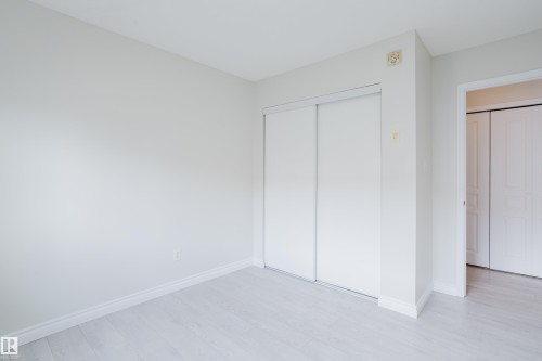 This room features light-colored walls, light-toned flooring, and a closet with sliding doors - 113 309 Clareview Station Drive, Edmonton, AB - Indoor Photo Showing Other Room
