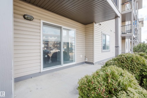 Exterior patio area featuring a sliding glass door and an outdoor light fixture - 113 309 Clareview Station Drive, Edmonton, AB - Outdoor With Exterior