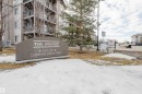 The property features a stone sign with directional information for "The Avenue" and "Clareview Station Drive." The building features exterior balconies with dark railings - 113 309 Clareview Station Drive, Edmonton, AB  - Outdoor 