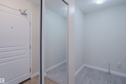 Entryway featuring a white door, a full-length mirror, and light-colored flooring - 113 309 Clareview Station Drive, Edmonton, AB - Indoor Photo Showing Other Room