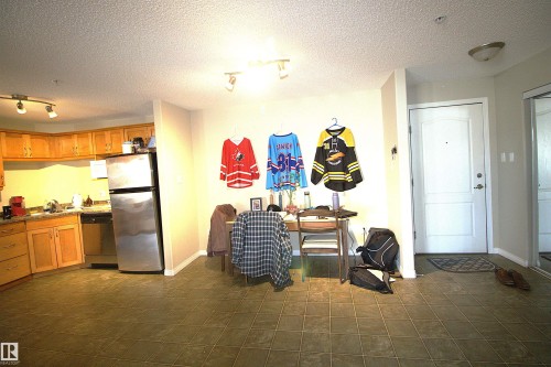 The kitchen features light wood cabinetry, stainless steel appliances, and a tiled floor - 1204 330 Clareview Station Drive, Edmonton, AB - Indoor Photo Showing Kitchen