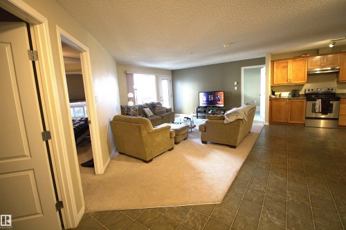 The living area features carpeting, while the kitchen and entryway include tiled flooring - 1204 330 Clareview Station Drive, Edmonton, AB - Indoor