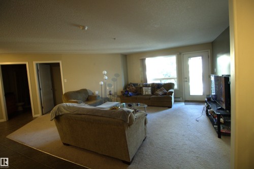 The property features carpeted floors in the main living space - 1204 330 Clareview Station Drive, Edmonton, AB - Indoor Photo Showing Living Room