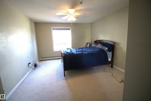 This room features light-colored carpeting, a window with a blind, and a ceiling fan - 1204 330 Clareview Station Drive, Edmonton, AB - Indoor Photo Showing Bedroom
