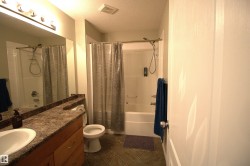Bathroom featuring a vanity with a large mirror, a shower-tub combination, and tiled flooring - 