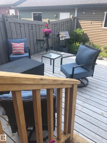 The property features a wooden deck with a privacy fence, string lights, and ample space for outdoor seating - 9084 Rosenthal Link, Edmonton, AB - Outdoor With Deck Patio Veranda With Exterior
