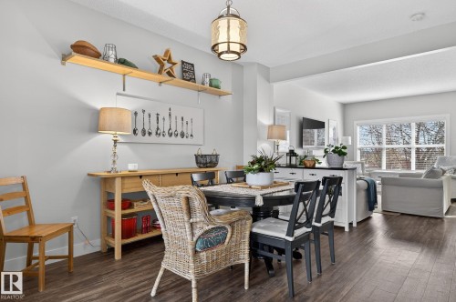 The dining area features dark wood flooring, a dining table with chairs, and overhead lighting - 9084 Rosenthal Link, Edmonton, AB - Indoor Photo Showing Dining Room