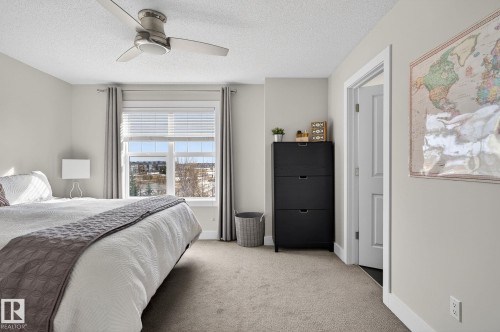 The room features light gray walls, a window with blinds and curtains, and a ceiling fan - 9084 Rosenthal Link, Edmonton, AB - Indoor Photo Showing Bedroom