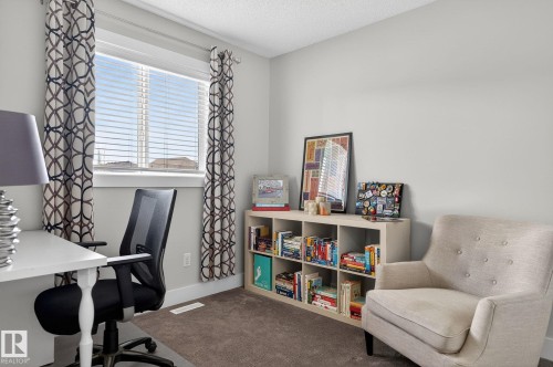 This room features a window with blinds and patterned curtains, light gray walls, and a carpeted floor - 9084 Rosenthal Link, Edmonton, AB - Indoor Photo Showing Other Room
