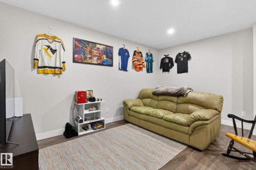 This space features neutral-toned walls, recessed lighting, and wood-look flooring - 9084 Rosenthal Link, Edmonton, AB - Indoor