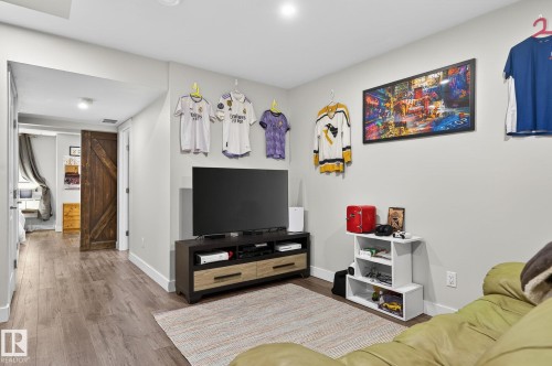 This inviting living space features light wood-style flooring and light-colored walls, providing a bright and airy atmosphere - 9084 Rosenthal Link, Edmonton, AB - Indoor