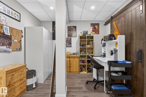 This versatile room features durable flooring, recessed lighting, and a barn door - 9084 Rosenthal Link, Edmonton, AB - Indoor