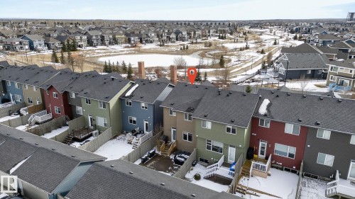 The property features a dark-colored roof and a private fenced yard with a deck - 9084 Rosenthal Link, Edmonton, AB - Outdoor
