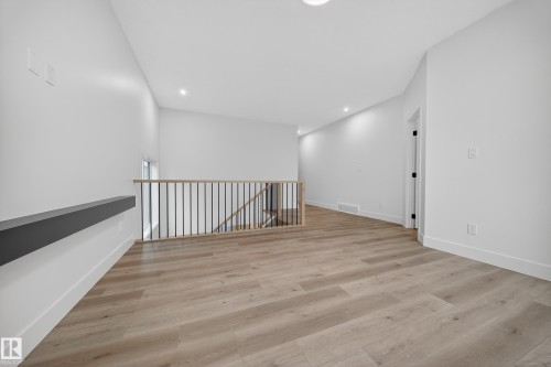 This bright space features light-toned flooring, white walls, and recessed lighting - 6117 Crawford Drive, Edmonton, AB 