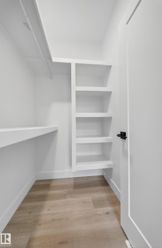 The property features a closet with built-in shelving and hanging space, complemented by light-toned flooring - 6117 Crawford Drive, Edmonton, AB 