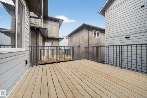 Spacious exterior deck with light-colored wood flooring and dark metal railings - 6117 Crawford Drive, Edmonton, AB 