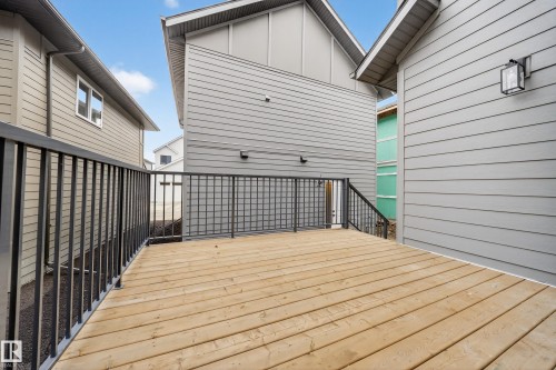 The property features a spacious wooden deck with black metal railings - 6117 Crawford Drive, Edmonton, AB 