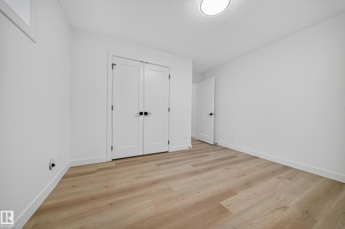 This room features light-toned flooring and white walls, creating a bright and airy atmosphere - 6117 Crawford Drive, Edmonton, AB 