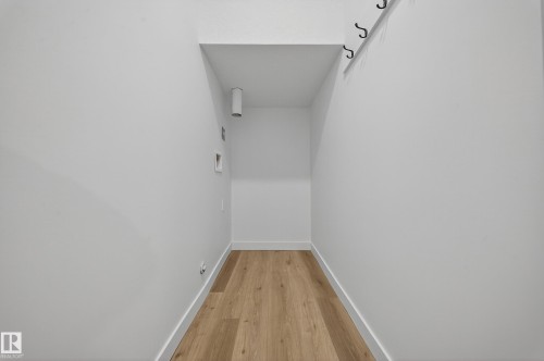 Dedicated laundry area featuring light wood flooring and white walls - 6117 Crawford Drive, Edmonton, AB 