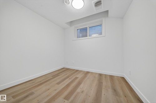 Room featuring light wood-style flooring and a window - 6117 Crawford Drive, Edmonton, AB 