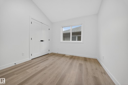 This room features light-toned flooring, white walls, and a window providing natural light - 6117 Crawford Drive, Edmonton, AB 
