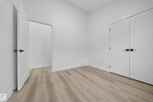 The room features light-toned plank flooring and crisp white walls - 6117 Crawford Drive, Edmonton, AB 