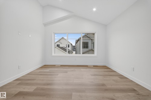 This bright room features a vaulted ceiling, recessed lighting, and light-toned flooring - 6117 Crawford Drive, Edmonton, AB 