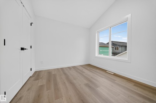 This room features light-toned flooring, white walls, and a window providing natural light - 6117 Crawford Drive, Edmonton, AB 
