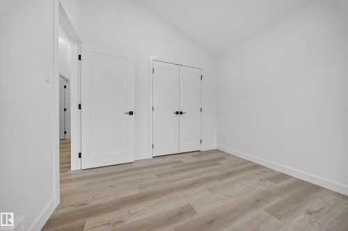 This room features light-colored plank flooring and white walls - 6117 Crawford Drive, Edmonton, AB 