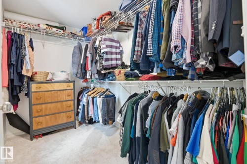 The property features a walk-in closet with carpeted flooring, white walls, and wire shelving and hanging rods for ample storage - 7235 112 Street, Edmonton, AB - Indoor With Storage