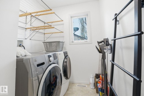 The laundry area features a window, light-colored flooring, and a wall-mounted drying rack - 7235 112 Street, Edmonton, AB - Indoor Photo Showing Laundry Room